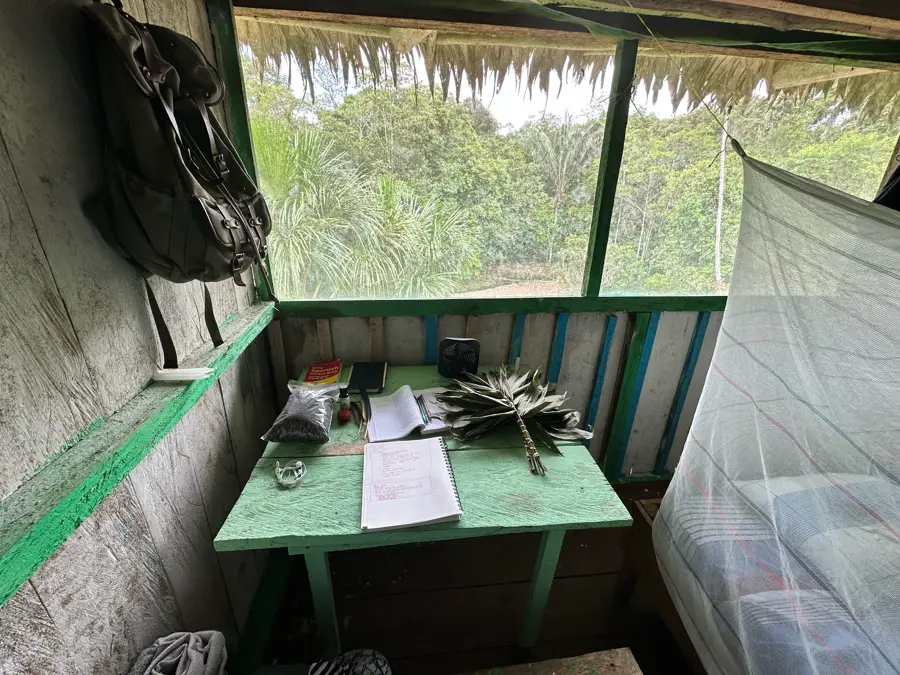 Inside a tambo: a notebook, a mosquito net, and the jungle outside